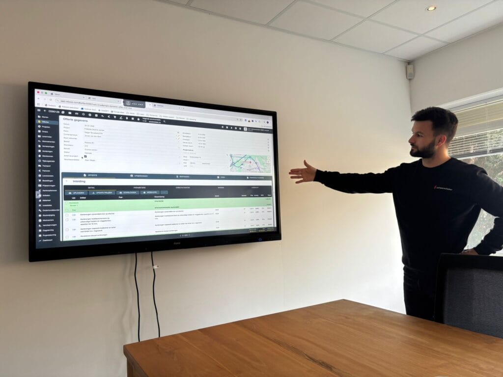 Medewerker toont Robaws-interface op groot scherm tijdens support en implementatie