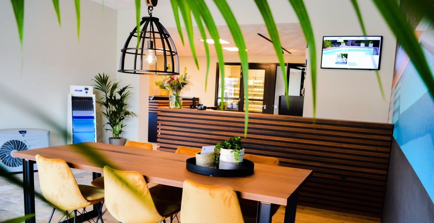 ontvangst- en overlegruimte in Di-Jo Zwembaden showroom met tafel, gele stoelen en balie