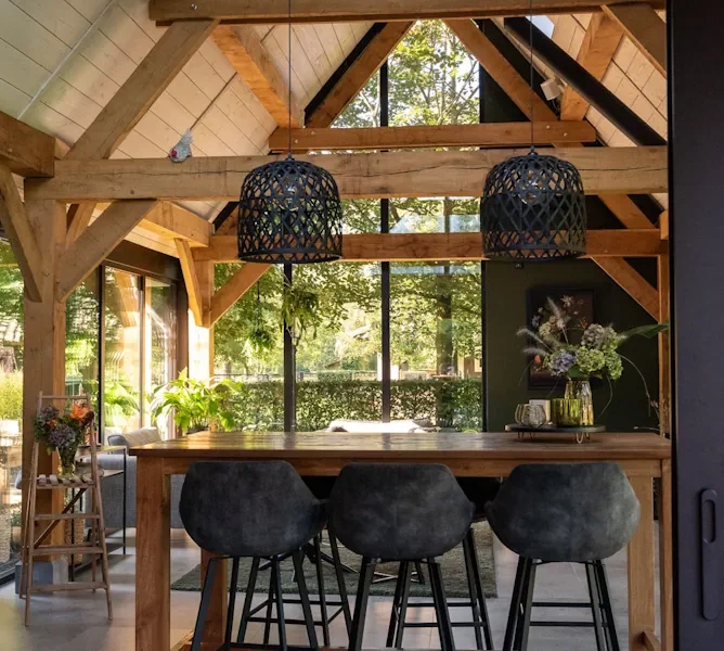 Houten buitenverblijf met bar en barkrukken in een groene tuin